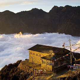 A Lodge At Sunset Above The Clouds