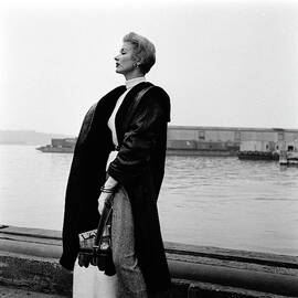 A Model Standing On A Dock In A Leather Coat by Richard Rutledge