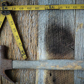 Old Tape Measure and Hammer for Construction on Rustic Wood Back by Brandon Bourdages