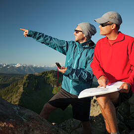 Two Men Use A Paper Map And A Compass by Christopher Kimmel