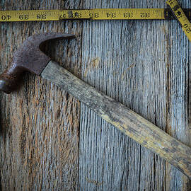Old Tape Measure and Hammer for Construction on Rustic Wood Back by Brandon Bourdages