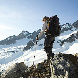 A Latina Woman Backpacks In The Snowy by Tim Matsui