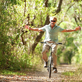 A Man Rides A Bicycle by Corey Rich