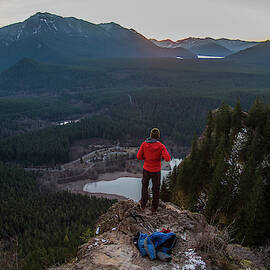 A Man Stands On The Edge Of A Rock by Michael Hanson