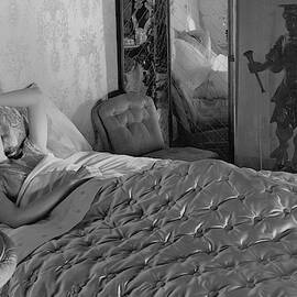 A Model In A Bed With Designer Bedding by Horst P. Horst
