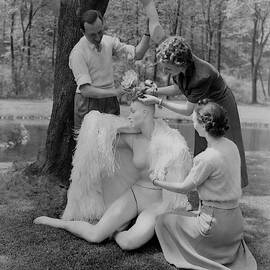 Andre Durst And Two Women Assembling A Mannequin by Andre Durst