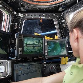 Astronaut In Iss Robotics Workstation by Science Photo Library