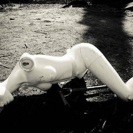 Broken abandoned doll lying on the ground