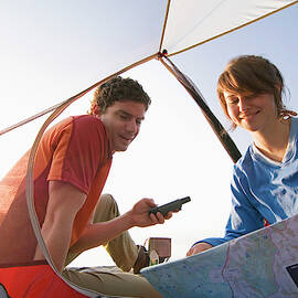 Campers Read Map In Tent by Lars Schneider