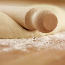 Close Up Of Rolling Pin On Dough by Adam Gault