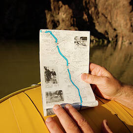 Hands Holding A River Map While Rafting by Corey Rich
