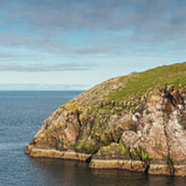 Lighthouse On Cliff Overlooking Blue by Fotovoyager