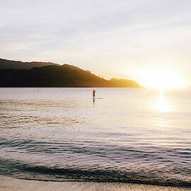 Man Paddle Boarding During Sunset by Ryan Tuttle