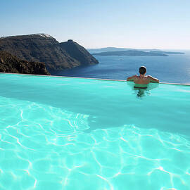 Man Relaxing Looking At Santorini by Peskymonkey