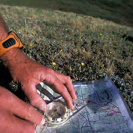 Man Uses Compass And Topographic Map by Corey Rich