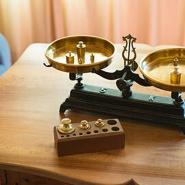 Old golden pair of scales with a set of weights by Matthias Hauser