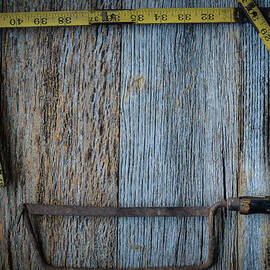 Old Tape Measure and Saw for Construction on Rustic Wood Backgro by Brandon Bourdages