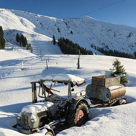 Old tractor in winter with lots of snow waiting for spring by Matthias Hauser