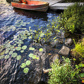 Rowboat at lake shore by Elena Elisseeva