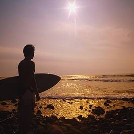 Surfer At The End Of The Day On The by Darren Greenwood