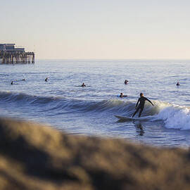 Surfing By The Newport Pier by Kyle Morris