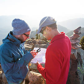 Two Men Use A Paper Map And A Compass by Christopher Kimmel