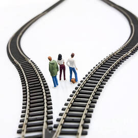 Figurines between two tracks leading into different directions symbolic image for making decisions. by BERNARD JAUBERT