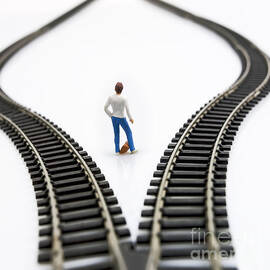 Figurine between two tracks leading into different directions symbolic image for making decisions. by BERNARD JAUBERT