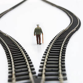 Figurine between two tracks leading into different directions symbolic image for making decisions. by BERNARD JAUBERT