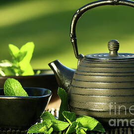 Black asian teapot with mint tea by Sandra Cunningham
