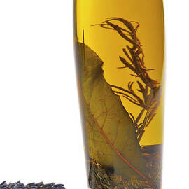 Bottle of herb-infused olive oil and lavender by Sami Sarkis Photography