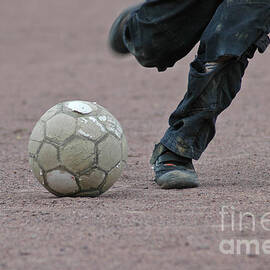 Boy playing soccer with a ball by Matthias Hauser