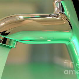 Chrome sink tap with running water by Sami Sarkis Photography