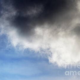 Commercial airplane in flight by storm clouds by Sami Sarkis Photography