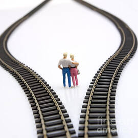 Couple two figurines between two tracks leading into different directions symbolic image for making decisions by BERNARD JAUBERT