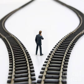 Figurine between two tracks leading into different directions  symbolic image for making decisions by BERNARD JAUBERT