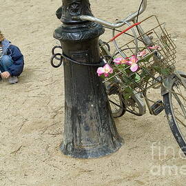 Girl playing with sand near bicycle by Sami Sarkis Photography
