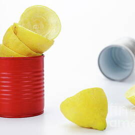 Squeezed citrus halves in red tin cans by Sami Sarkis Photography