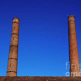 Two chimneys against blue sky by Sami Sarkis Photography