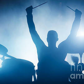 Drummer playing on drums on music concert. Club lights by Michal Bednarek