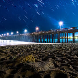 Star trails over beach and pier by Chris Giordano