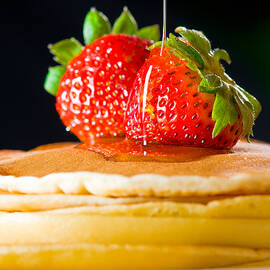 Strawberry butter pancake with honey maple sirup flowing down