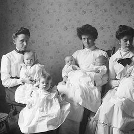 3 women holding 5 babies in day nursery