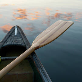 A Boat And Paddle Sit On A Tranquil by Keith Levit / Design Pics
