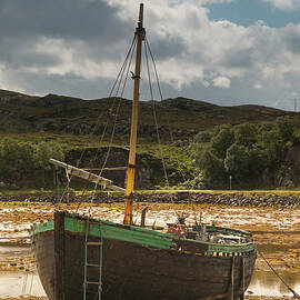 A Boat Sitting On The Shore At Low Tide by John Short / Design Pics