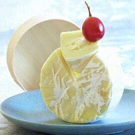 A Camembert On Its Side With A Grape On Top by Raben, Sven C.