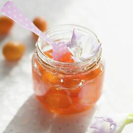 A Jar Of Kumquat Jam With A Spoon by Au Petit Gout Photography Llc