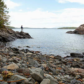 A Man Looks From A Cove Along The by Deddeda / Design Pics