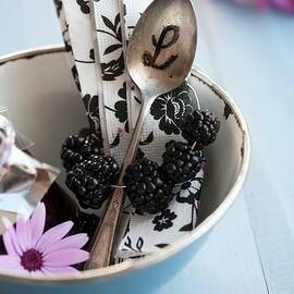 A Napkin With A Blackberry Napkin Ring And A Spoon With Initials In A Blue Enamel Bowl by Martina Schindler