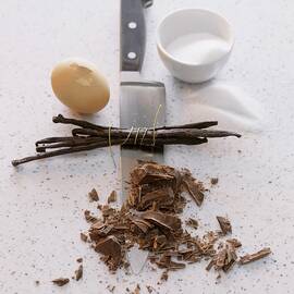 A Still Life Featuring A Knife, Sugar, An Egg, Vanilla Pods And Chocolate by Michael Wissing